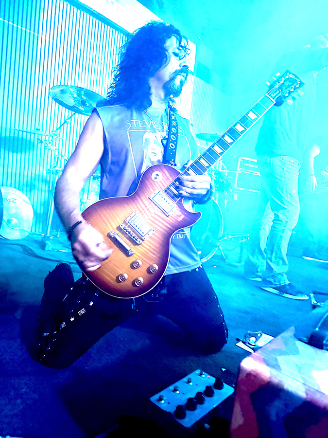 Mike Ruggirello plays his Gibson Les Paul in blue light.